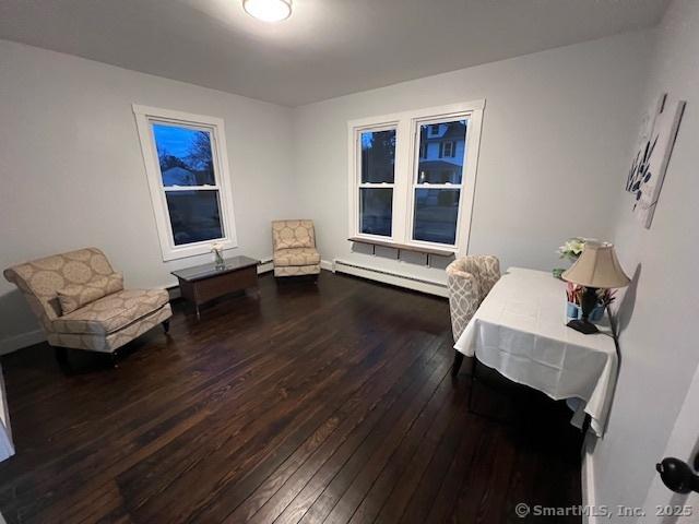 living area featuring baseboard heating, a baseboard radiator, and hardwood / wood-style flooring