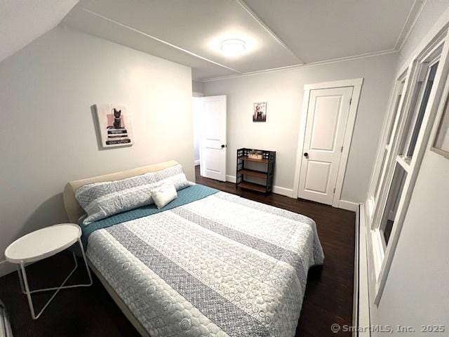 bedroom with baseboards and dark wood-type flooring