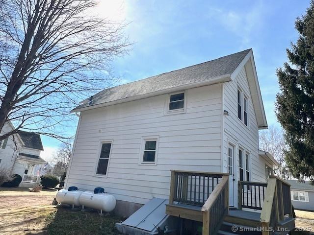 rear view of house with a wooden deck and a shingled roof