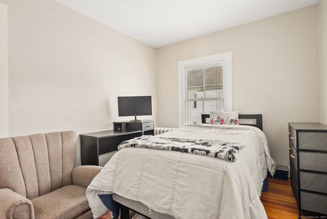 bedroom with radiator and wood finished floors