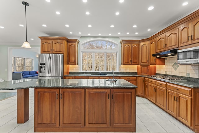 kitchen featuring under cabinet range hood, a wealth of natural light, light tile patterned flooring, and appliances with stainless steel finishes