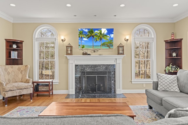 living room featuring recessed lighting, a premium fireplace, wood finished floors, and crown molding