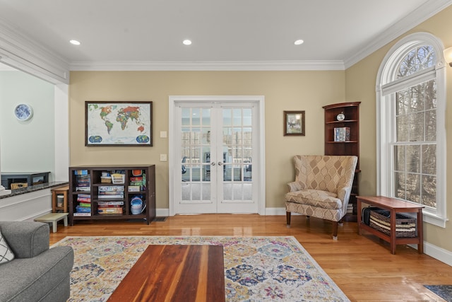 sitting room featuring a wealth of natural light, crown molding, and wood finished floors