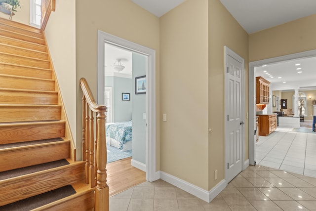 interior space with stairway, light tile patterned floors, and baseboards