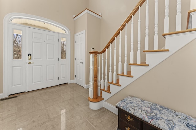 tiled entryway with stairs, baseboards, and visible vents