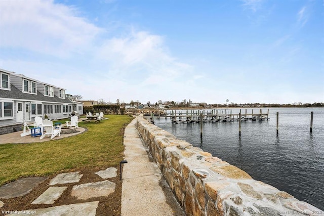 dock area featuring a patio area, a lawn, and a water view