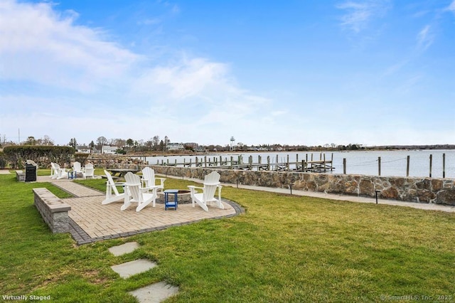 view of yard featuring a water view, a boat dock, and a patio area