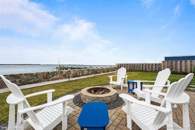 view of patio with a water view, fence, and an outdoor fire pit