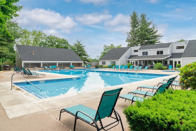 community pool with a patio and fence