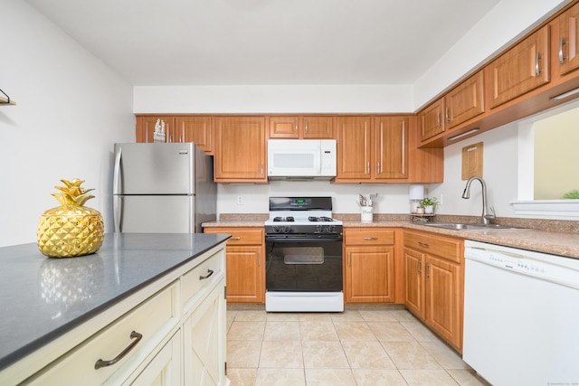 kitchen featuring a sink, white appliances, brown cabinetry, and light tile patterned floors