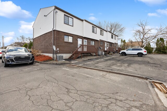 exterior space with uncovered parking and brick siding