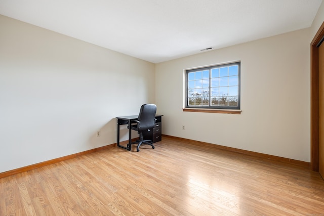 unfurnished office featuring light wood-style flooring, visible vents, and baseboards