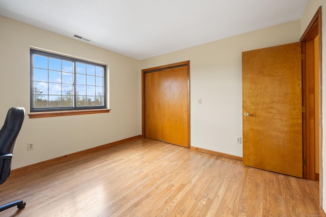 unfurnished office featuring visible vents, light wood finished floors, and baseboards