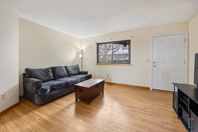 living area with visible vents, baseboards, and light wood-style floors