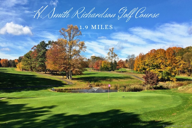 view of property's community featuring view of golf course and a yard