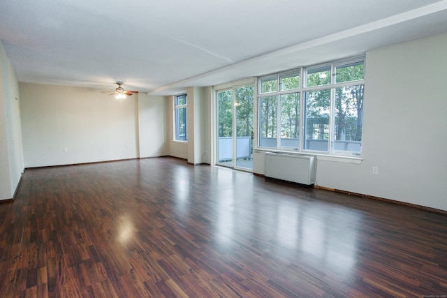 unfurnished room featuring baseboards, radiator, wood finished floors, and a ceiling fan