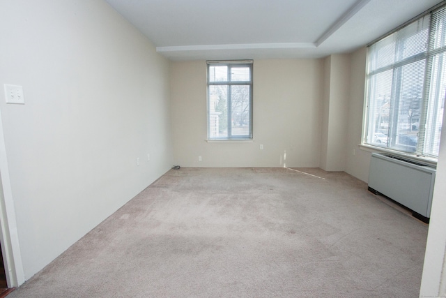carpeted empty room featuring radiator heating unit