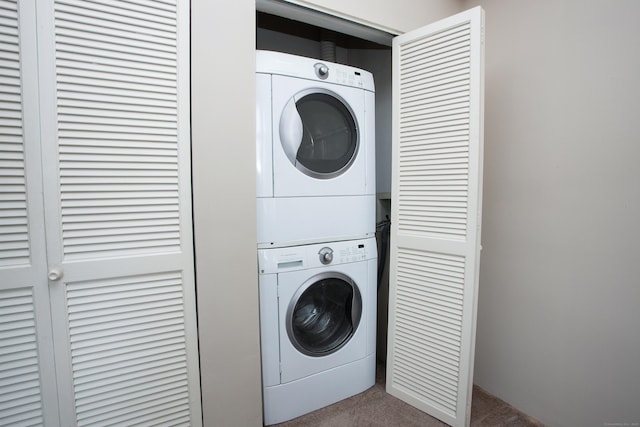 washroom with laundry area, carpet flooring, and stacked washing maching and dryer