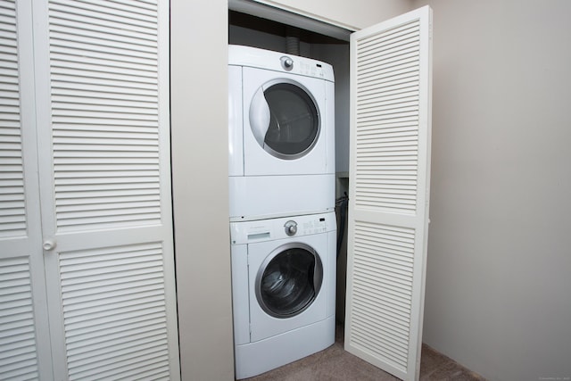 laundry area featuring stacked washer and dryer, laundry area, and carpet