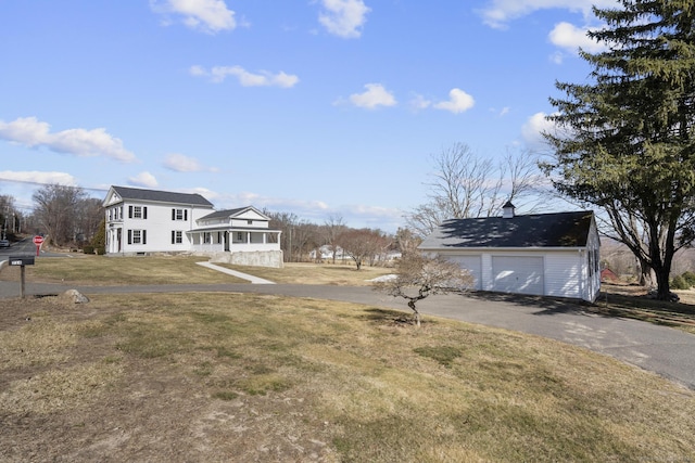 view of yard featuring a detached garage and an outdoor structure