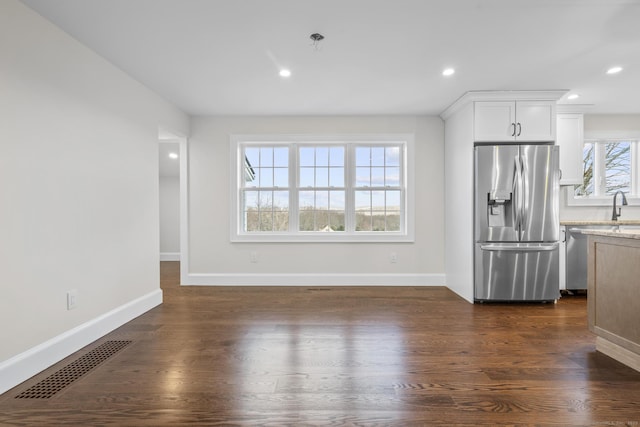 kitchen featuring dark wood-style floors, visible vents, appliances with stainless steel finishes, and a sink