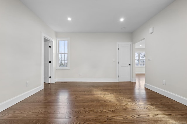 unfurnished room featuring recessed lighting, wood finished floors, and baseboards