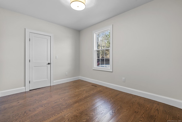 unfurnished room featuring baseboards and wood finished floors