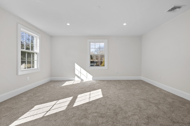 carpeted spare room with recessed lighting, baseboards, and visible vents