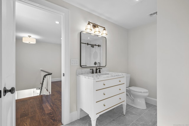 full bath featuring visible vents, baseboards, toilet, vanity, and a shower