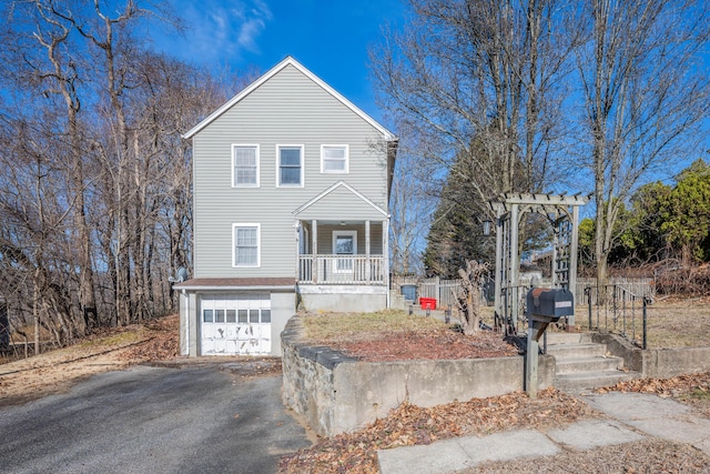 view of front of home with aphalt driveway, a porch, and an attached garage