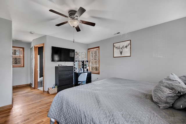 bedroom with baseboards, light wood-type flooring, multiple windows, and visible vents