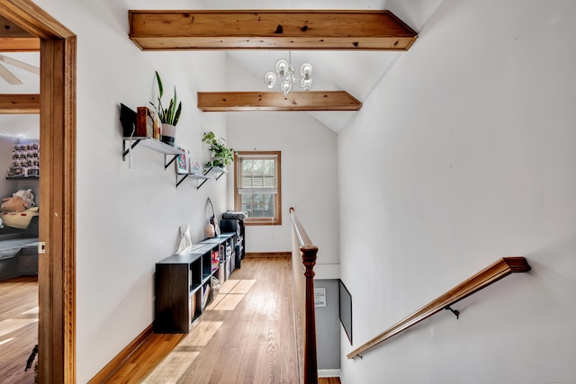 interior space featuring hardwood / wood-style floors, lofted ceiling with beams, baseboards, and an inviting chandelier