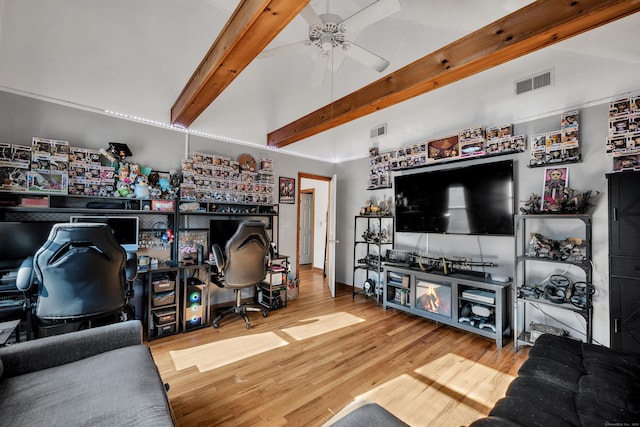 living area with visible vents, vaulted ceiling with beams, a ceiling fan, and wood finished floors