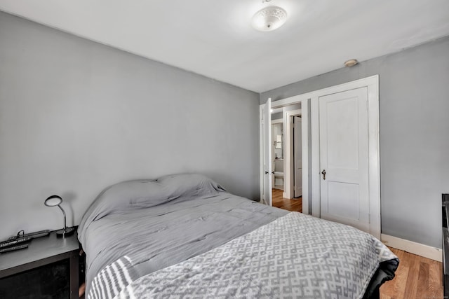 bedroom with wood finished floors and baseboards