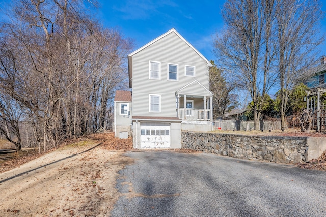 view of front facade with covered porch, driveway, and an attached garage