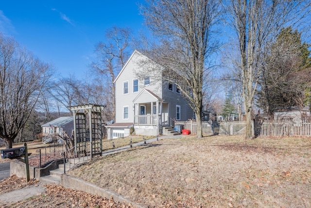 view of front of property featuring covered porch and fence