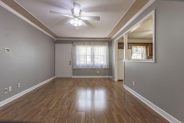 unfurnished room featuring a ceiling fan, dark wood-type flooring, and crown molding