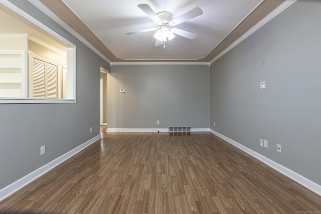 empty room with visible vents, baseboards, ornamental molding, wood finished floors, and a ceiling fan