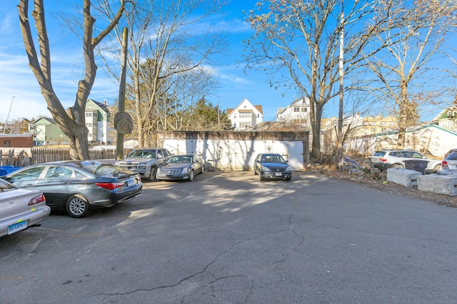 uncovered parking lot featuring fence and a residential view