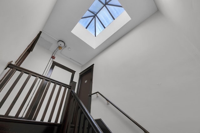 staircase featuring lofted ceiling with skylight