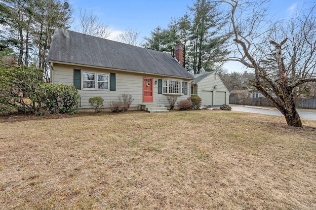 view of front of property featuring an outbuilding, driveway, a front lawn, entry steps, and a chimney