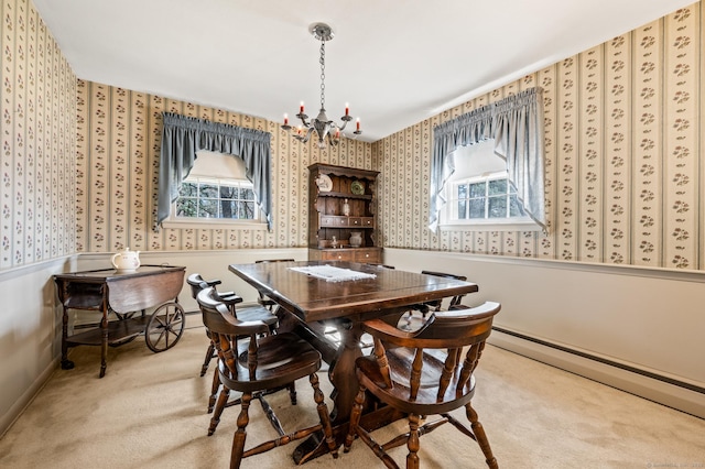 carpeted dining room with a chandelier, a wainscoted wall, baseboard heating, and wallpapered walls