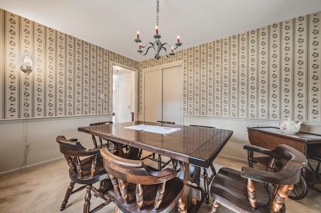 dining area with baseboards, light carpet, and a notable chandelier