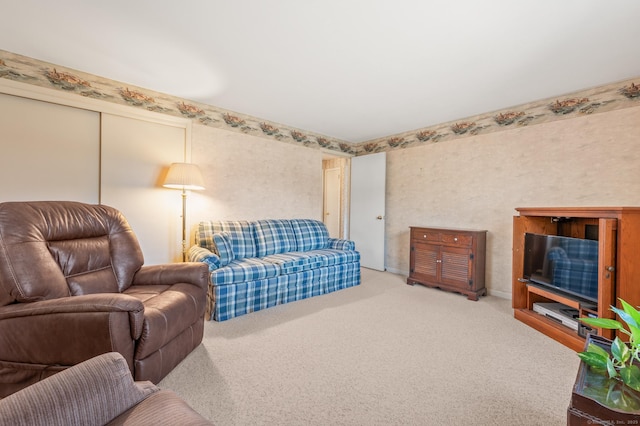 carpeted living area featuring wallpapered walls