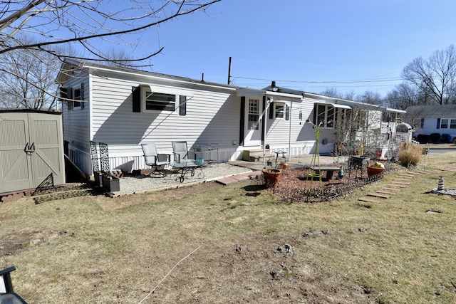 back of property featuring an outbuilding, a storage shed, a lawn, and entry steps