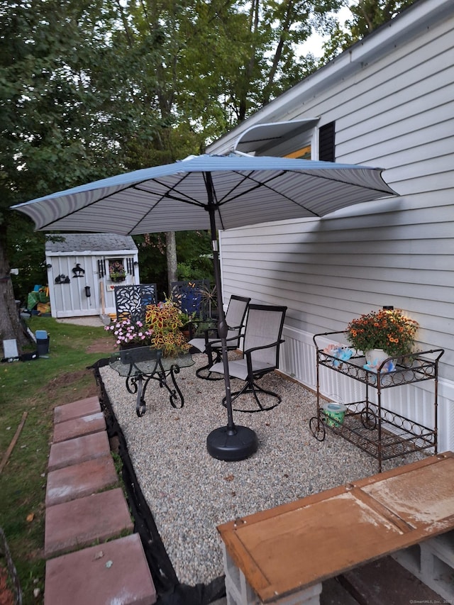 view of patio with a storage shed and an outbuilding