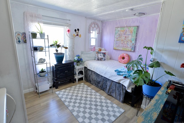 bedroom featuring a textured ceiling and wood finished floors