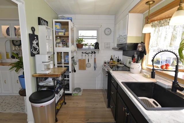 kitchen with light countertops, range with electric cooktop, light wood-style floors, and a sink