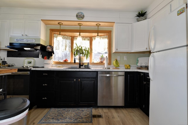 kitchen with range with electric cooktop, under cabinet range hood, stainless steel dishwasher, freestanding refrigerator, and white cabinets