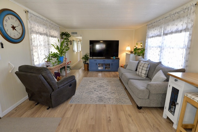 living room with light wood finished floors, visible vents, and a healthy amount of sunlight